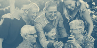 happy multigenerational family looking at video on cell phone, family flourishing